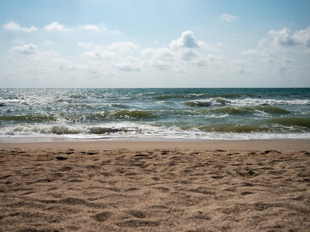 Foto costa del mar de arena olas del mar hasta el horizonte
