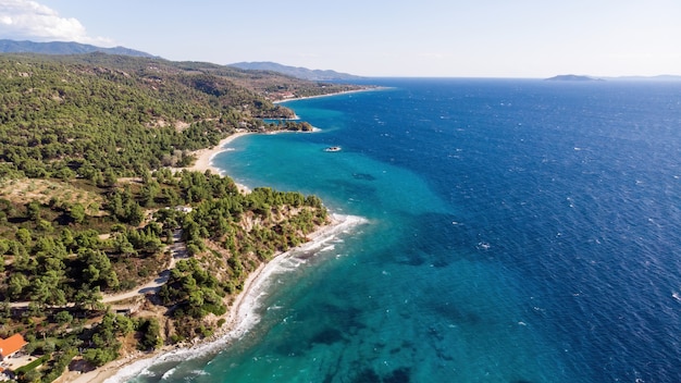 Costa del mar Egeo de Grecia, colinas rocosas con árboles y arbustos en crecimiento, amplia extensión de agua