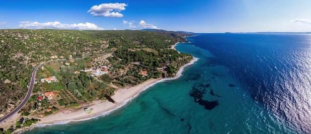 Costa del mar Egeo de Grecia, colinas rocosas con árboles y arbustos en crecimiento, pocos edificios cerca de la costa, amplia extensión de agua