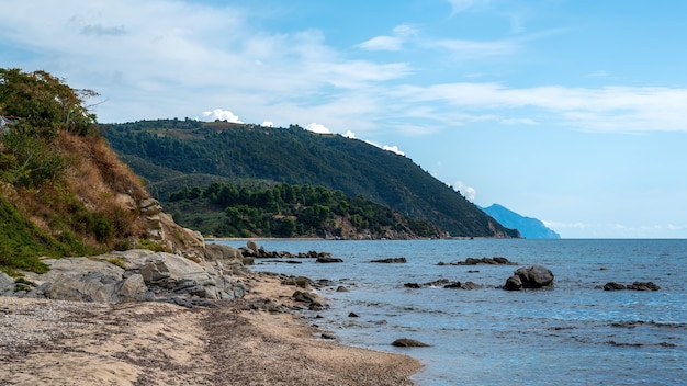 Costa del mar Egeo en Ouranoupolis con rocas en el agua en Grecia