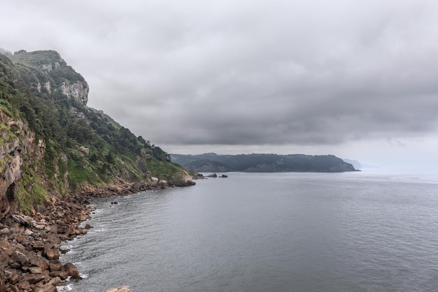 costa de la península ibérica acantilados rocosos mar gris bajo fuertes nubes tormentosas Cabo de Santa Catalina