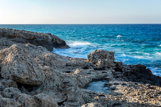 Costa rochosa do mar turquesa contra o fundo de um céu azul claro Belas paisagens e relaxamento