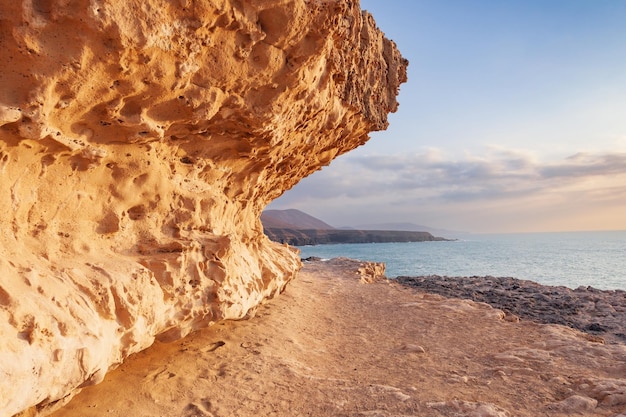 Costa rochosa do oceano atlântico ao pôr do sol, fuerteventura, espanha