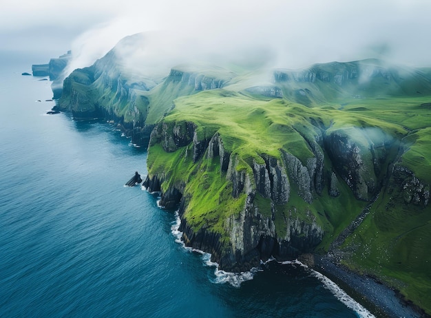 Costa rocosa con colinas verdes y un mar nebuloso