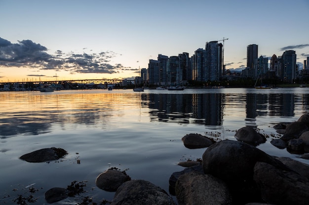 Costa rocosa en un parque en False Creek con el centro de Vancouver en segundo plano.