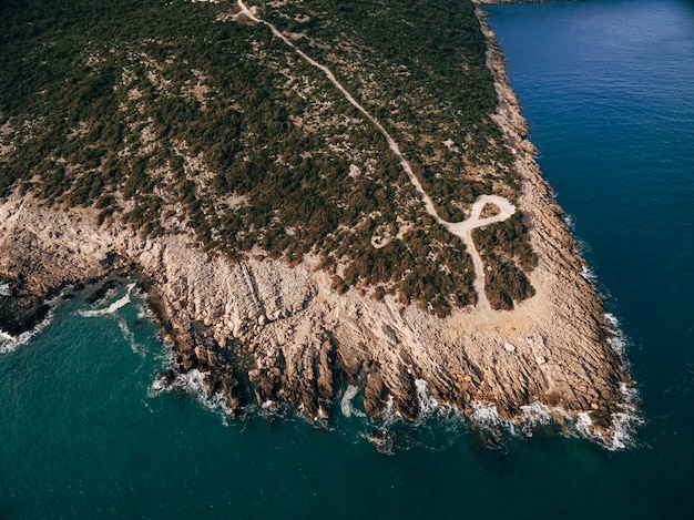 Costa rocosa de la península de lustica en montenegro vista aérea drone olas espumosas golpean la costa