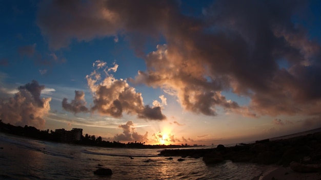 Costa tropical del Caribe en las nubes - puesta de sol sobre el mar, gran angular