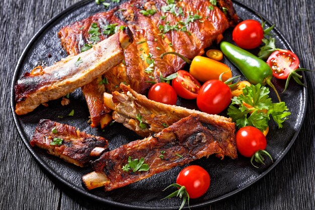 Costelas de churrasco com tomate e pimentão na chapa preta