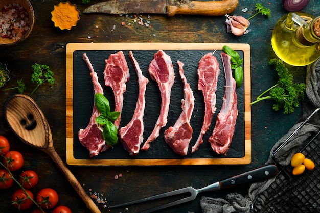 Costelas de cordeiro cruas frescas em uma mesa de cozinha escura Estilo rústico Foto para o catálogo