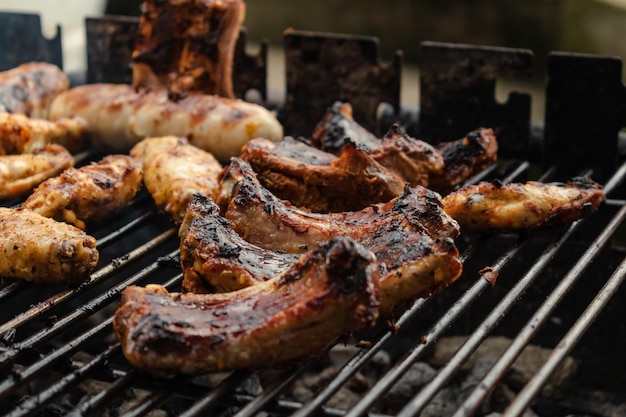 Costelas de frango marinadas e salsichas colocadas no churrasco