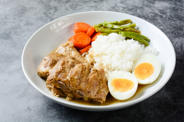 Costelas de porco assado com arroz, ovo cozido e vegetais