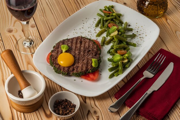 Costeleta de carne grelhada com gema e feijão de aspargos