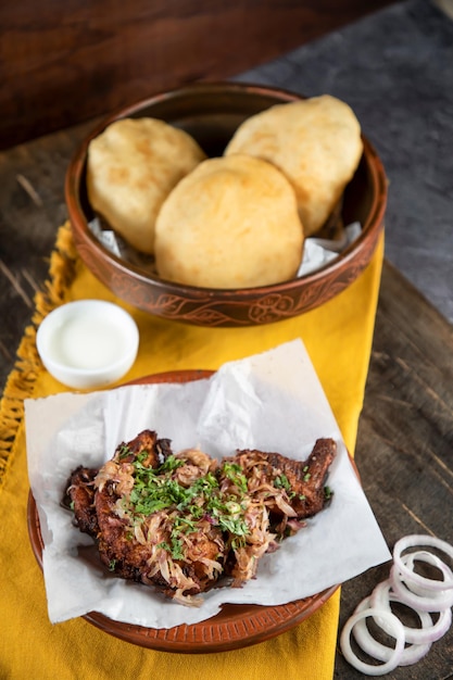 Costeleta de frango ou chap com dal puri raita e cebola isolada na mesa vista de bangladeshi indiano e comida paquistanesa