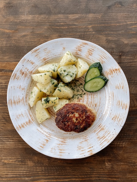 Costeleta de peixe com batatas e legumes. Costeleta de lúcio com ervas e vegetais vista superior