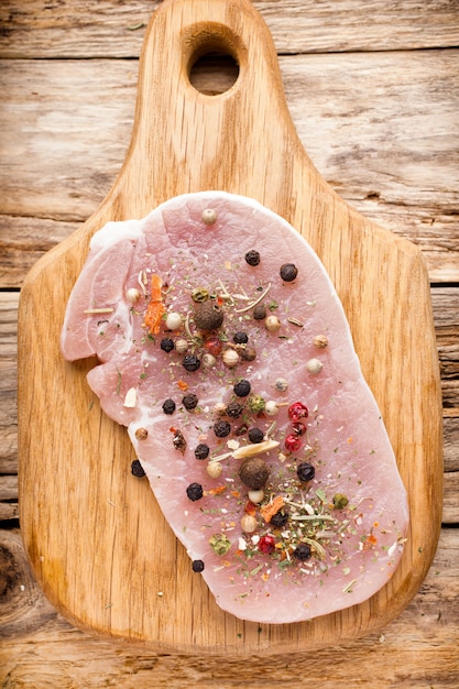 Costeleta de porco, fatias de carne em um fundo de madeira.