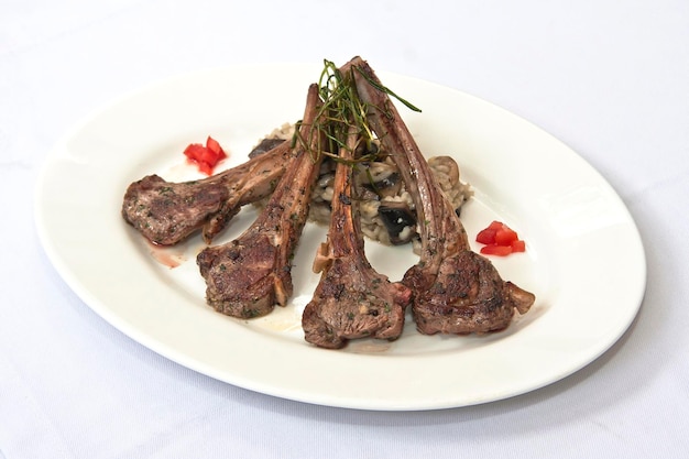 Costeletas de carne de cordeiro fritas com arroz de risoto na gastronomia de comida de mesa de restaurante