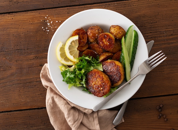 Costeletas de carne fresca com batatas novas e salada