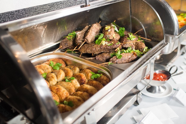 Costeletas de carne quente em tigela na mesa de buffet