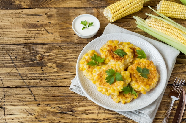 Costeletas de grãos de milho enlatado com salsa em um prato.