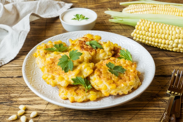 Costeletas de grãos de milho enlatado com salsa em um prato.