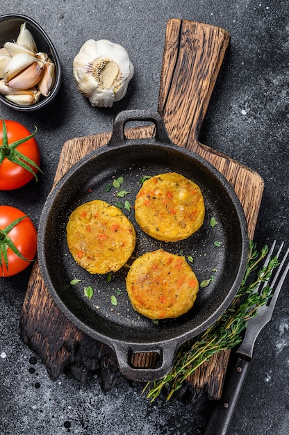 Costeletas de rissóis de legumes cozidos para hambúrgueres veganos. Fundo escuro.