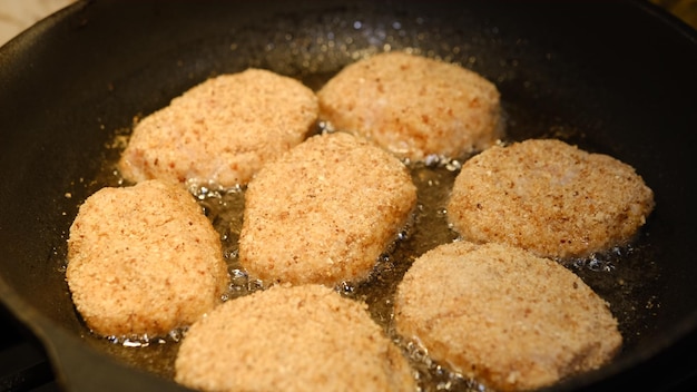 Costeletas fritas em uma frigideira com óleo de girassol Menu rústico Comida rústica tradicional Closeup Costeletas de hambúrguer caseiro