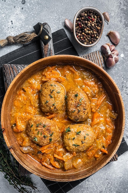 Costeletas ou bolinhos de peixe com atum em molho de tomate fundo cinza vista superior