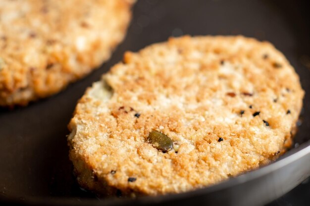 Costeletas vegetarianas são fritas em uma panela Comida alternativa de carne Costeletas de sementes de feijão Closeup macro