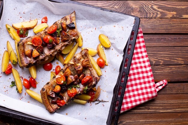 Costelinha de porco com legumes em um fundo de madeira