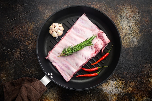 Costelinha de porco crua fresca temperada com temperos, em frigideira de ferro fundido, vista de cima plana