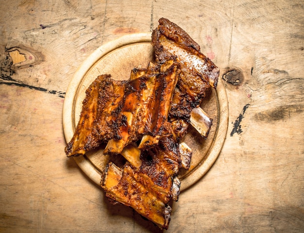 Costelinha de porco de churrasco na mesa de madeira.