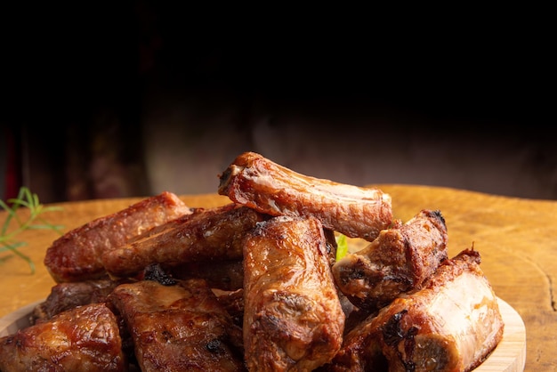 Costelinha de porco frita com limão e especiarias na madeira disposta em madeira rústica clara, foco seletivo.