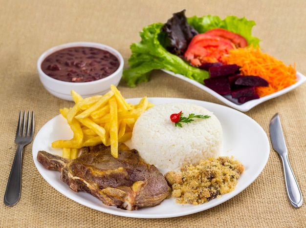 Costilla, arroz, frijoles, papa y migas con acompañamiento