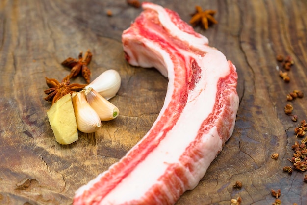 Costillas con anís estrellado de ajo y otras especias en una tabla de cortar antigua