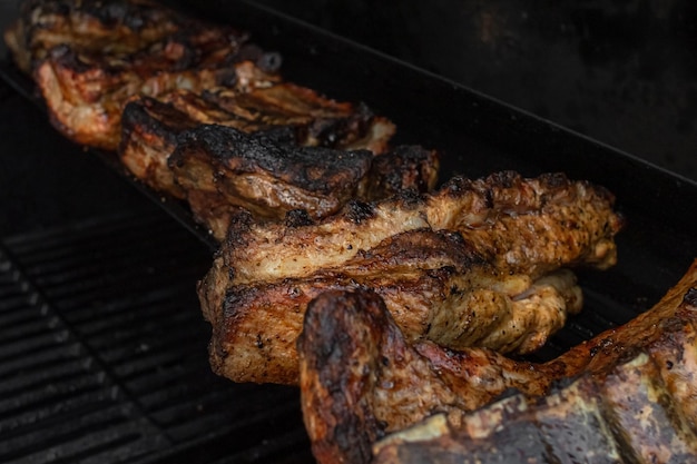 Costillas asadas. Carne a la parrilla. Cocine al fuego. Una corteza rojiza. Alimentos grasos. Carne de cerdo a la parrilla.