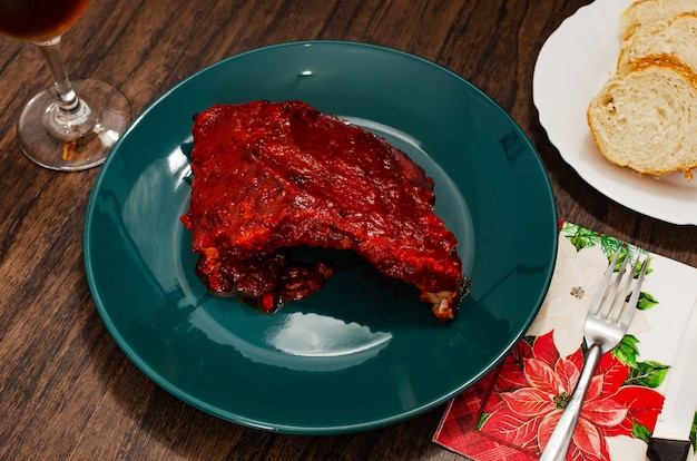 Costillas asadas marinadas con salsa barbacoa en mesa de madera