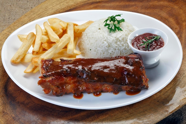 Costillas a la barbacoa con arroz y patatas fritas