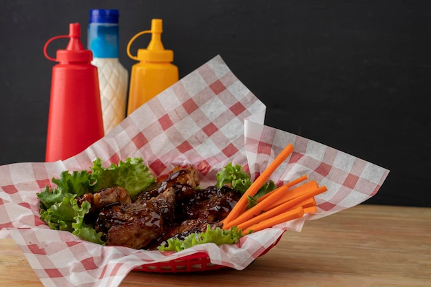 Costillas a la barbacoa de comida mexicana en una canasta con lechuga y zanahoria