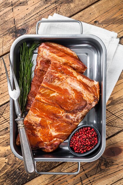 Costillas de cerdo ahumadas americanas en bandeja de acero con hierbas Fondo de madera Vista superior