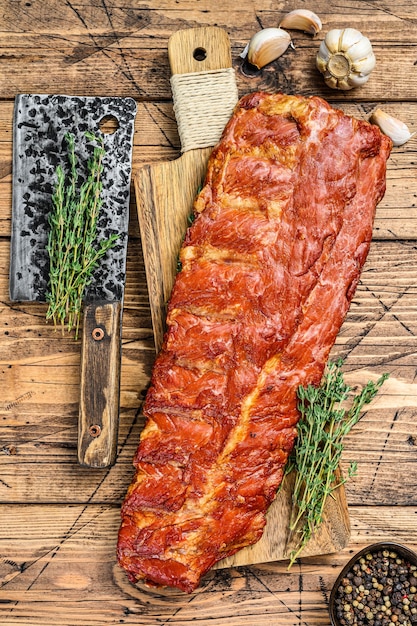 Costillas de cerdo ahumadas sobre una tabla de cortar. Fondo de madera. Vista superior.