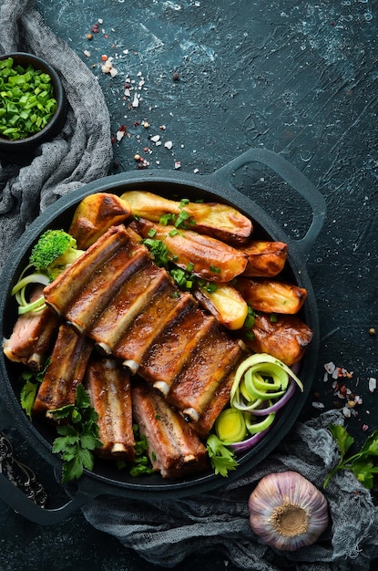 Costillas de cerdo al horno con patatas en una sartén Barbacoa Vista superior Espacio libre para el texto