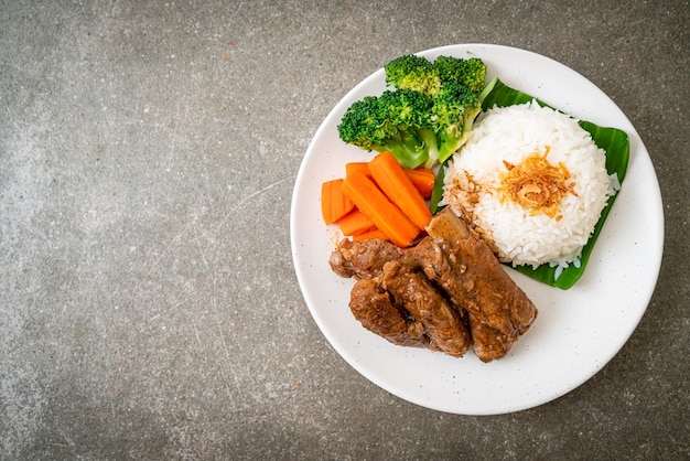 Costillas de cerdo al horno con salsa y arroz