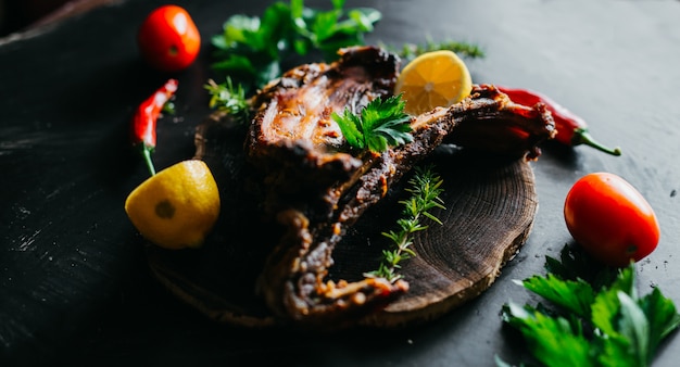 Costillas de cerdo al horno sentado en una mesa rústica con verduras