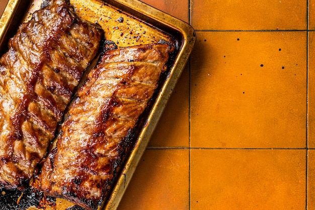 Costillas de cerdo asadas a la barbacoa Fondo naranja Vista superior Espacio de copia