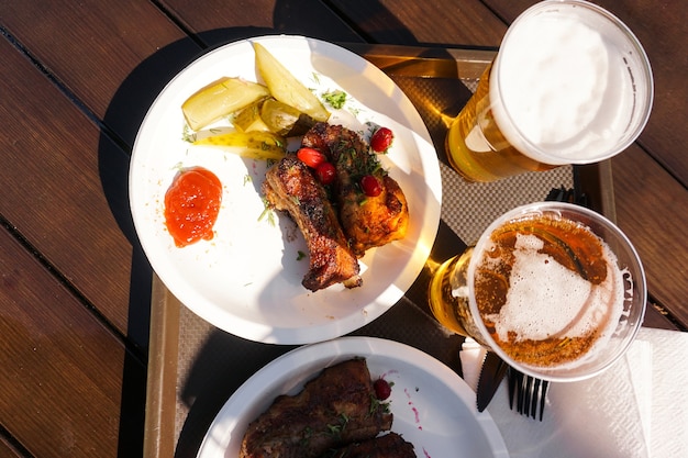 Costillas de cerdo en una bandeja y cerveza light street food festival comida en un día soleado