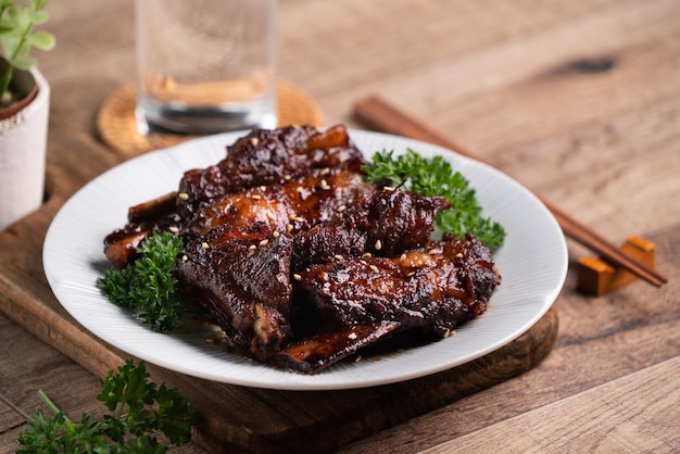 Costillas de cerdo a la barbacoa en un plato sobre fondo de mesa de madera