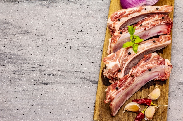 Costillas de cerdo cruda sobre fondo de hormigón de piedra gris