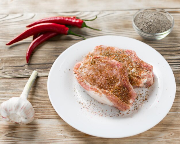 Costillas de cerdo crudas con especias sobre un fondo de madera