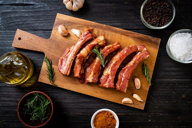 Costillas de cerdo crudas frescas listas para asar con ingredientes