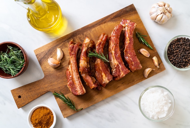 Costillas de cerdo crudas frescas listas para asar con ingredientes